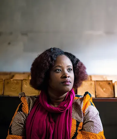 Woman in colorful outfit looking thoughtfully.
